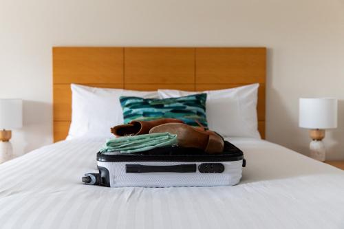 a teddy bear sitting inside of a suitcase on a bed at Tea House Motor Inn in Bendigo