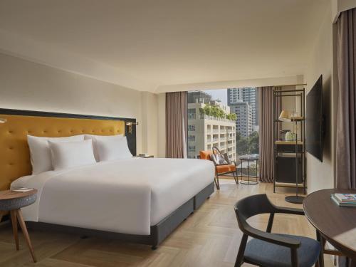 バンコクにあるPublic House Hotel - Sukhumvit 31のベッド付きのホテルルームで、市街の景色を望めます。