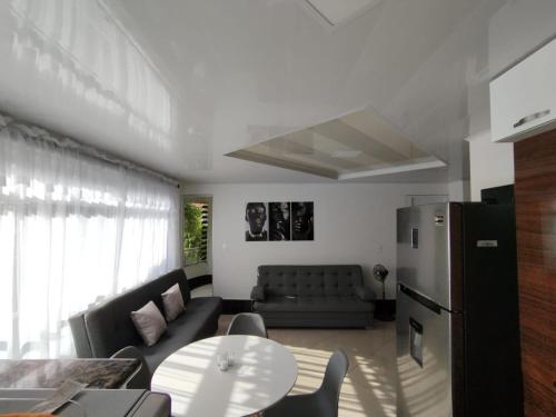 a living room with a couch a table and a refrigerator at Apartamentos Florida Nueva estadio in Medellín