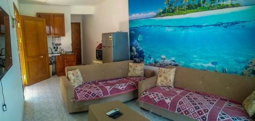 uma sala de estar com um sofá e uma cozinha em Sea Park Chalet-Stella Di Mare Sea view -Families em Az Za‘faranah