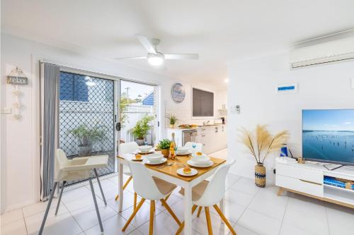 a kitchen and dining room with a table and chairs at Sapphire Sands 1 52 Boulder Bay Rd air con Wi Fi Cot and Highchair in Fingal Bay