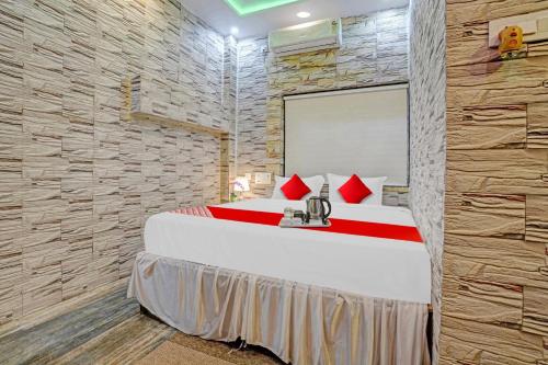 um quarto com uma cama grande e uma parede de pedra em Flagship Lemon Tree Inn em Rāipur