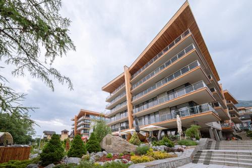 an apartment building with a garden in front of it at LUXURY Apartment Hrebienok D210 in Smokovce