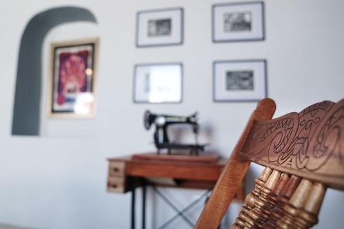 una silla de madera frente a una mesa y cuadros en la pared en Habitacion Azul / Casa del Café, en Campeche