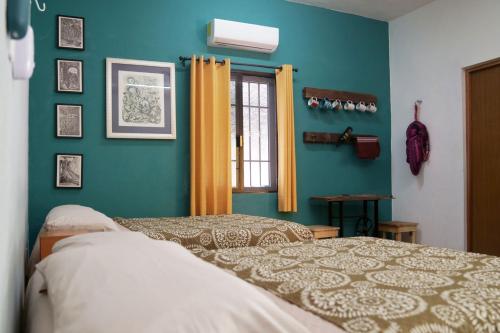 a bedroom with a bed and a green wall at Habitacion Azul / Casa del Café in Campeche