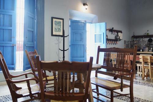 a dining room with blue doors and a table and chairs at Habitacion Azul / Casa del Café in Campeche