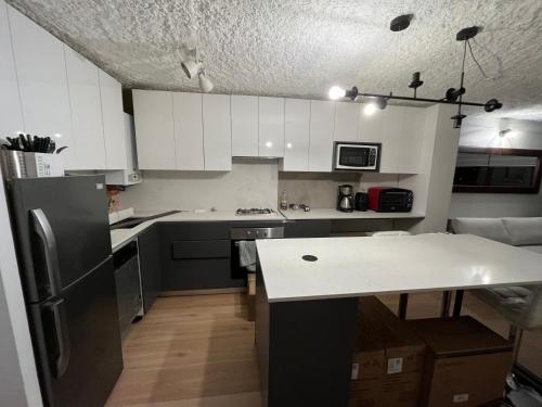 uma cozinha com armários brancos e um balcão branco em Ski in-out Apartment in El Colorado em El Colorado