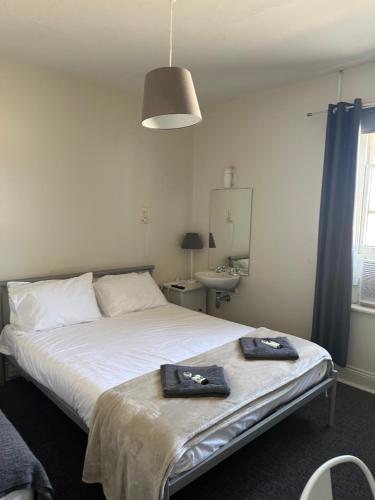 a bedroom with a bed with two towels on it at Cornwall Hotel in Moonta