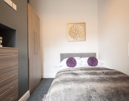 um quarto com uma cama grande e almofadas roxas em Centralized Private 4 BR House at Hanley with Free Parking em Etruria