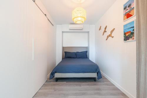 ein Schlafzimmer mit einem Bett in einem weißen Zimmer in der Unterkunft Appartement 6 couchages dans résidence avec piscine in Juan-les-Pins