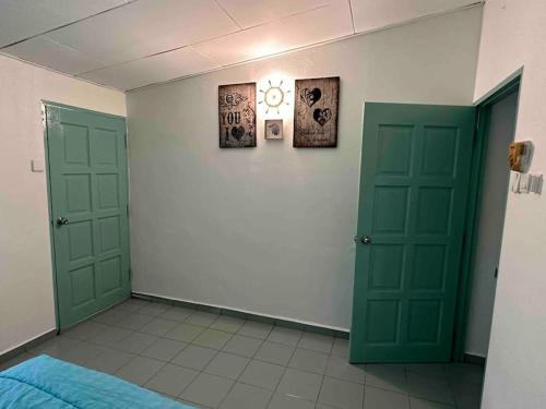 a room with two green doors in a room at AAA Homestay Georgetown Penang in Ayer Itam