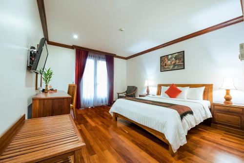 a hotel room with a bed and a tv at Royal Crown Hotel & Spa in Siem Reap