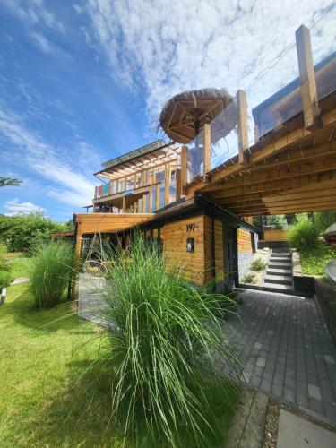 a house with a wooden roof on top of it at Villa Solina in Zawóz