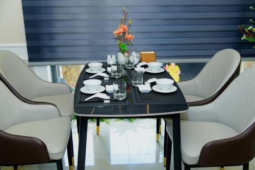 a black table with white chairs around it at Hera Luxury Hotel in Ho Chi Minh City