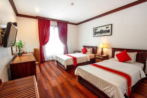 a hotel room with two beds and a television at Royal Crown Hotel & Spa in Siem Reap