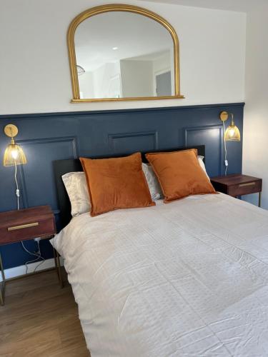 Un dormitorio con una cama grande con un espejo en la pared. en The Raven's Loft by Harry Potter, en Garston