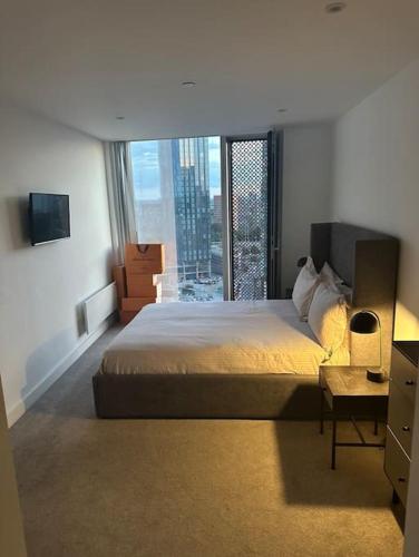 a bedroom with a large bed and a large window at Lux 2 Bedroom MCR Deansgate in Manchester