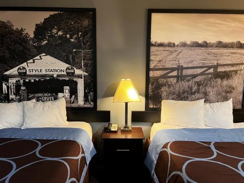ein Hotelzimmer mit 2 Betten und einem Schild an der Wand in der Unterkunft Super 8 by Wyndham Center in Center