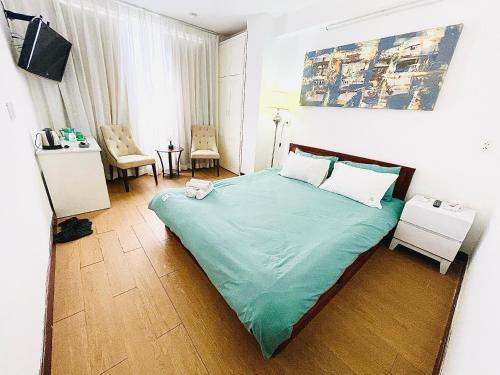 a bedroom with a bed with a green comforter at Onestar Danang Riverside in Da Nang