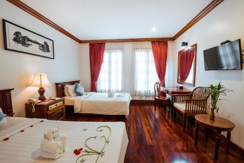a hotel room with two beds and a tv at Royal Crown Hotel & Spa in Siem Reap