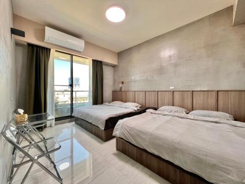 um quarto com 2 camas e uma mesa de vidro em T-HOUSE em Taitung City