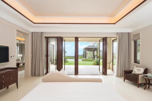 a bedroom with a bed and a living room with a tv at The Westin Zhujiajian Resort, Zhoushan in Zhoushan