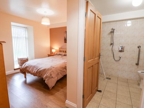 a bedroom with a bed and a shower at Mulgrave Cottage in Staithes