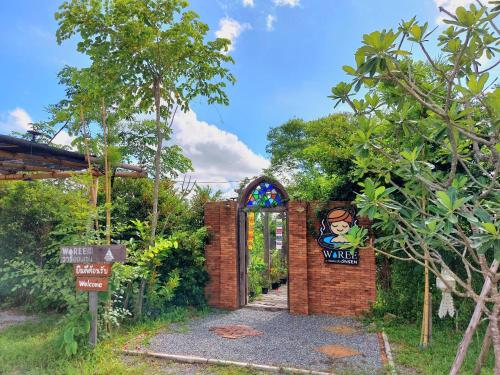 una entrada a un jardín con un arco de ladrillo en Waree Onsen Resort en Lamphun