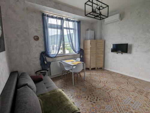 sala de estar con sofá y mesa en Sphera Bagebi Apartment en Tiflis