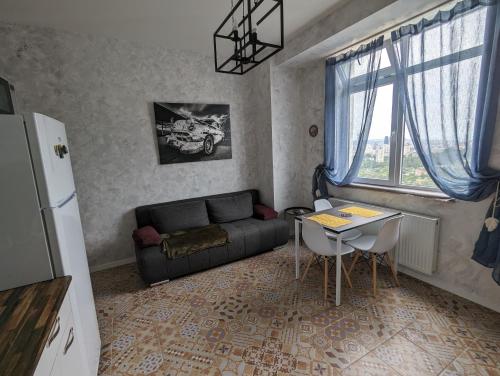 a living room with a couch and a table at Sphera Bagebi Apartment in Tbilisi City