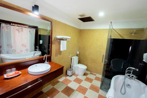 a bathroom with a tub and a sink and a shower at Royal Crown Hotel & Spa in Siem Reap