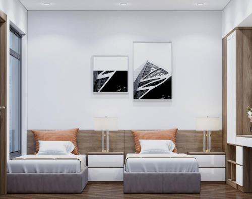 a living room with two beds and two pictures on the wall at Phong Lan Apartments in Hai Phong
