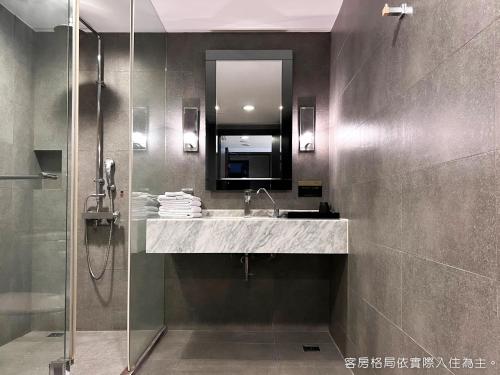 y baño con lavabo y ducha con espejo. en Talmud Hotel Kaohsiung LoveRiver en Kaohsiung
