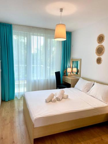 a bedroom with a large bed with two towels on it at Europe Holiday Apartments First Sea Line Coast in Pomorie