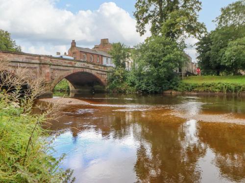 a bridge over a river in a town at Blacksmith Cottage in Appleby