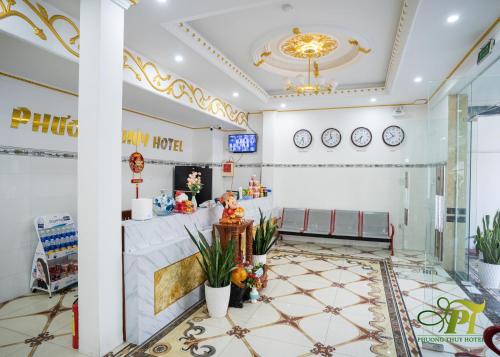 a lobby of a restaurant with a table and clocks at Phuong Thuy Hotel in Can Tho