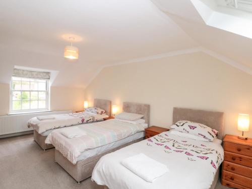 a bedroom with two beds and a window at Bella's Cottage in Great Driffield