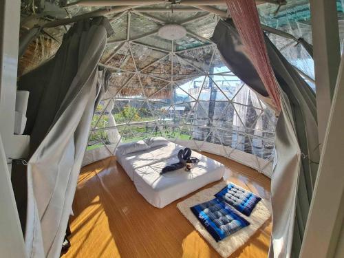 a room with a bed in a tent with a window at อิงเหนือ โฮมสเตย์ in Ban Muang Kut