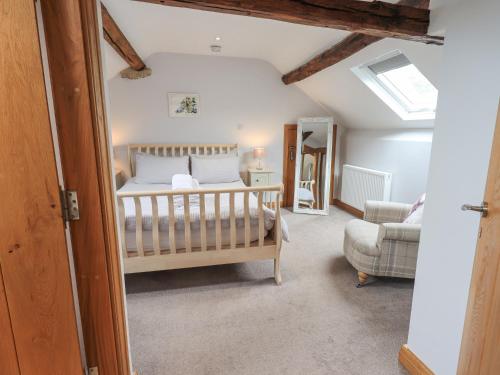 1 dormitorio con cuna en una habitación en Satterthwaite Farmhouse - Sleep 8 en Grizedale