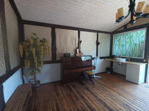 een kamer met een piano, een bureau en een raam bij Pie lacuksa in Tīnūži