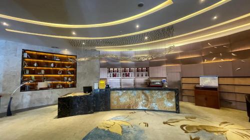 a restaurant with a counter and a bar in a room at Ramada Foshan Hotel in Foshan