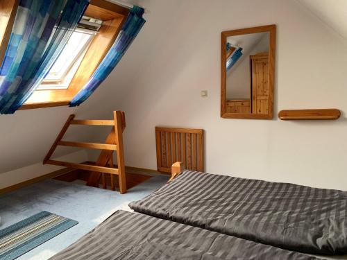 Ferienwohnung Buhne 11 - Friedrichskoog-Spitze - gegenüber Eltern-Kind-Klinik في فريادريتشسكوغ: غرفة نوم مع سرير ومرآة على الحائط
