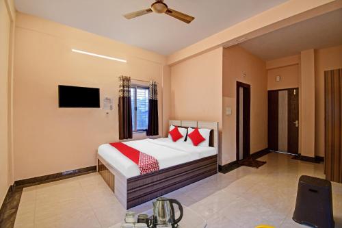 - une chambre avec un lit doté d'oreillers rouges et une télévision dans l'établissement Flagship Crown Tower, à Kolkata