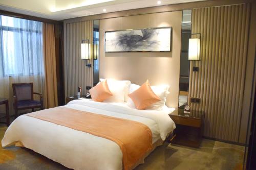 a hotel room with a large bed with pillows at Ramada Foshan Hotel in Foshan