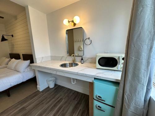 a kitchen with a sink and a microwave on a counter at Sierra Motor Lodge - A Sierra Blue Hotel in Mojave