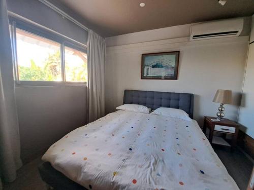 a bedroom with a large bed and two windows at Tropical 3-bedrooms Coastal Residence Creolia in Grand Baie