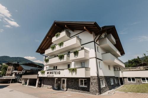 a large white building with plants on it at Knappensteig Appartements in Wagrain