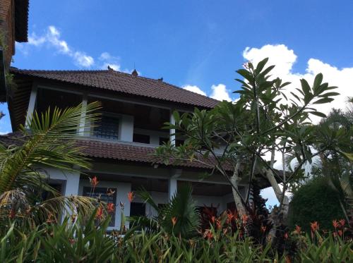 un edificio con árboles delante de él en Gerebig Bungalow, en Ubud