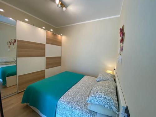 um quarto com uma cama com um edredão azul e um espelho em Appartamento a 200 mt dal mare em Rimini
