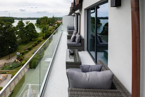 a balcony with couches and a view of the water at High Class Suites Mazuria in Mrągowo